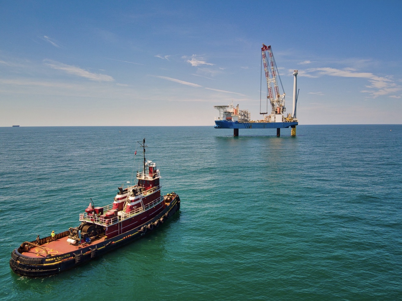Aerial view of tugboat near the VOLE AU VENT jack-up installation vessel during offshore wind turbine installation