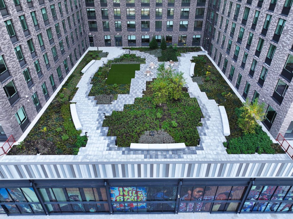 Aerial photo of a landscaped courtyard between brick residential buildings.